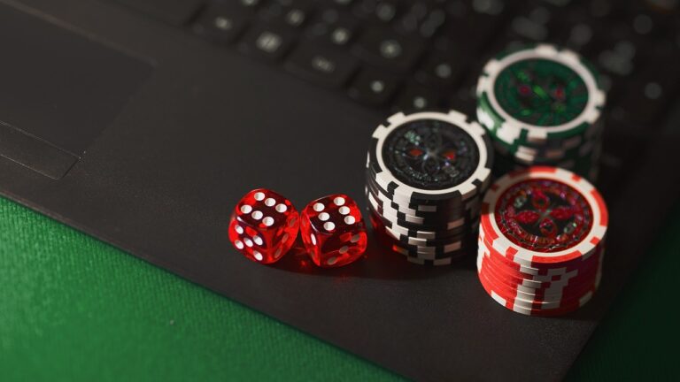 Person spielt konzentriert Online-Poker am Laptop mit steuerlichen Unterlagen daneben